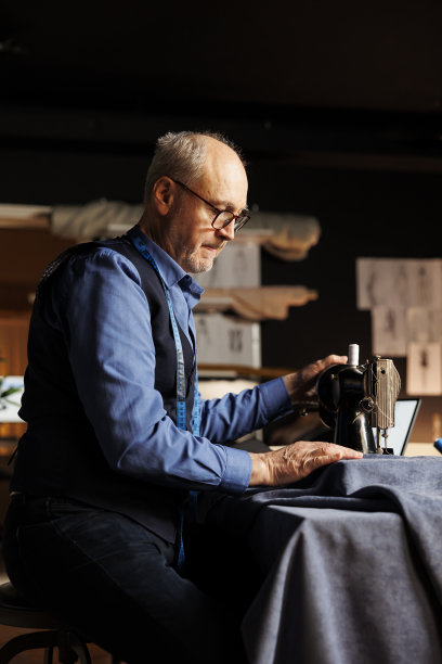 裁缝一丝不苟地裁剪布料图片下载