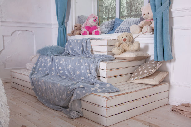 儿童房的窗台设计。坐、玩和存放玩具的地方。木制的讲台——一个箱子，一个沙发。DIY内部。图片下载