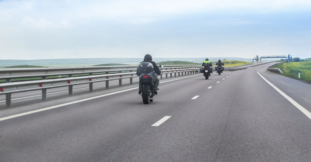 骑摩托车的人骑在乡间小路上。图片下载