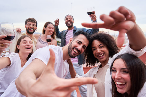 一群混血儿朋友在户外聚会上用手指做着相框手势的快乐自拍。图片下载