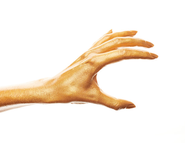 双手涂上金色的颜料。金手指。女性的手被孤立在白色背景上。白人女性放松的手显示符号和手势。图片下载