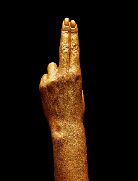 双手涂上金色的颜料。金手指。女性的手被孤立在白色背景上。白人女性放松的手显示符号和手势。图片下载