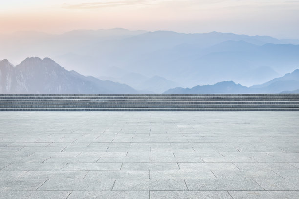 阳光明媚的白天，空旷的广场人行道和山景图片下载