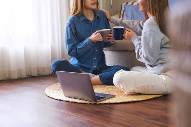 两个女人在家里用笔记本电脑交谈、碰肩、互相搀扶的特写图片下载