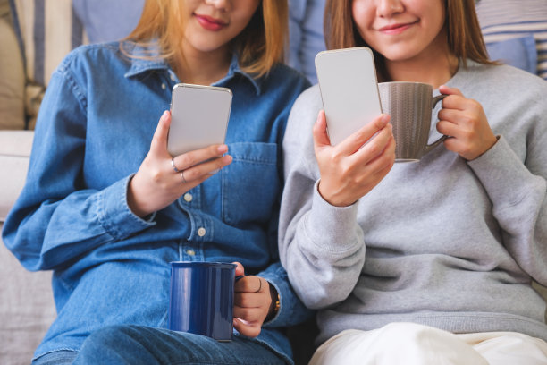 一对年轻夫妇的特写图像，女人一起使用和看手机图片下载