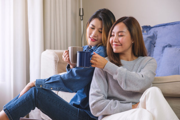 一对年轻夫妇的肖像，女人们一起碰杯喝咖啡图片下载