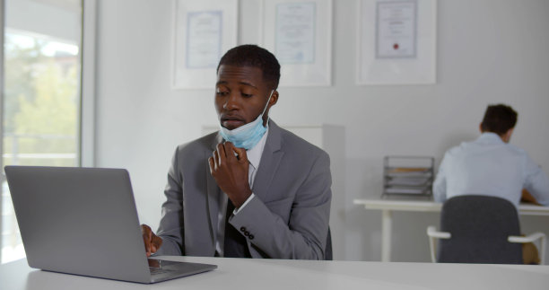 非洲商人摘下安全口罩，在工作场所呼吸新鲜空气图片下载