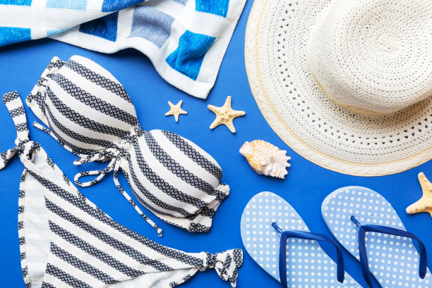 女子泳装和沙滩配饰平铺上视图彩色背景夏季旅游概念。比基尼泳衣，草帽和高跟鞋。复制空间俯视图图片下载