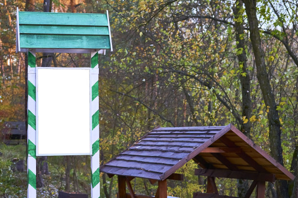 绿色框架的木制盾牌广告牌用来写文字，一个凉亭用来在森林里野餐图片下载