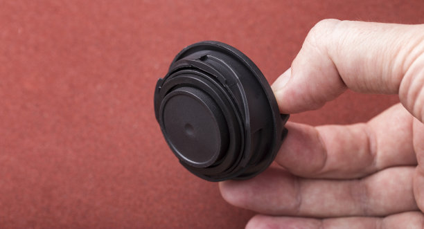 修理工手里拿着黑色的汽车加油盖。特写镜头图片下载