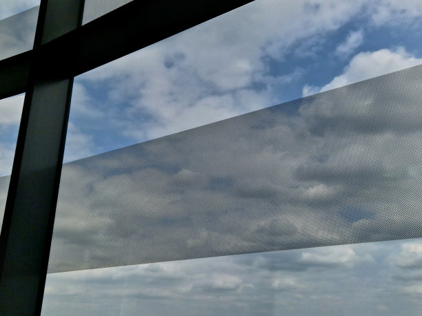 用于房屋或公司办公室窗户上的自粘穿孔贴纸。透明和阴影功能。立面结构的设计元素和带有印刷的广告横幅图片下载