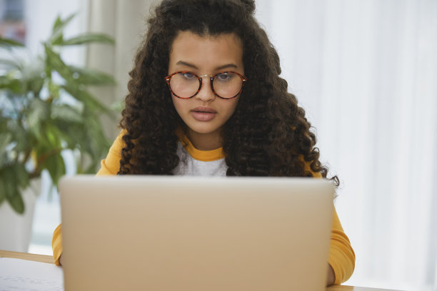 漂亮的学生坐在她的电脑前图片下载