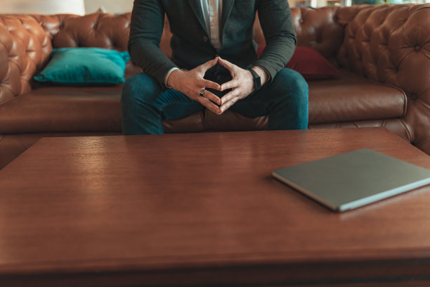 西装革履的商人坐在沙发上，手拉着手的特写。经营理念图片下载