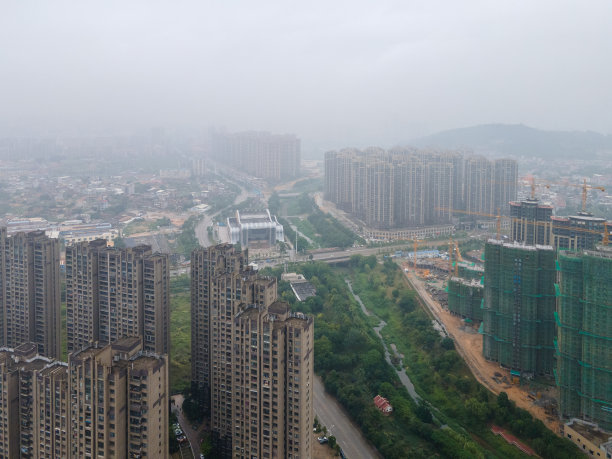 云雾缭绕的城市里新建的住宅楼和高速公路图片下载