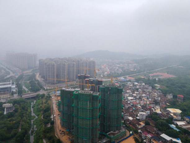 云雾缭绕的城市里新建的住宅楼和高速公路图片下载