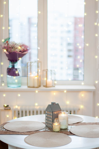 燃烧的蜡烛，复古的灯光和香槟酒杯的圣诞餐桌布置。温馨舒适的氛围图片下载