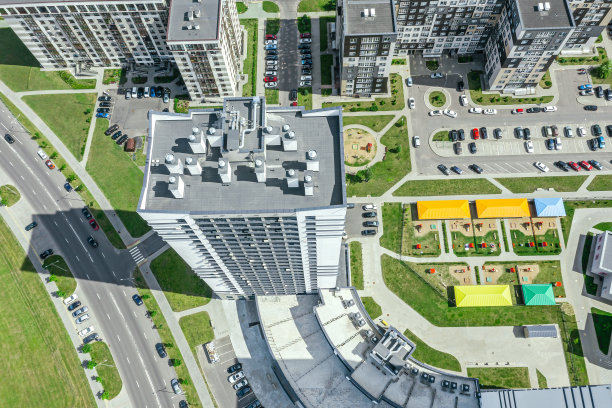 城市居住区，有公寓楼和带操场的庭院。阳光明媚的夏日鸟瞰图。图片下载