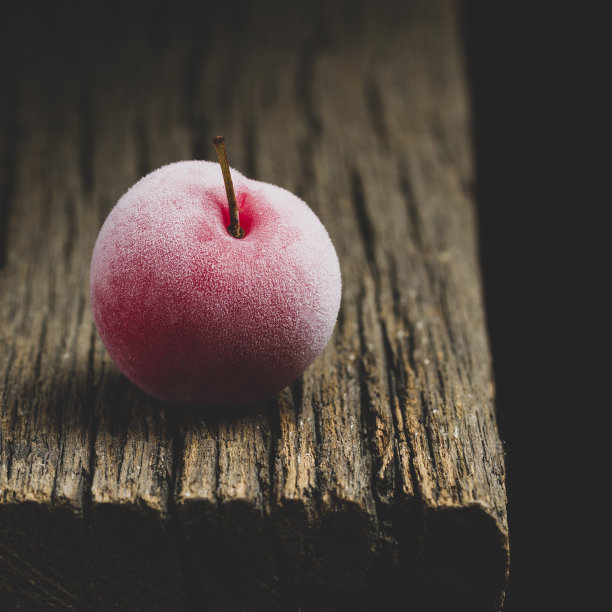 美味的李子在古老的木头和黑暗的背景图片下载