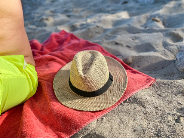 沙滩浴巾上的草帽图片下载