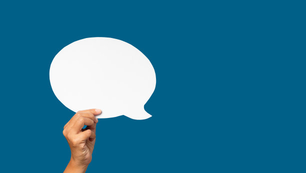 手握一个空的白色演讲泡沫在蓝色的背景图片下载