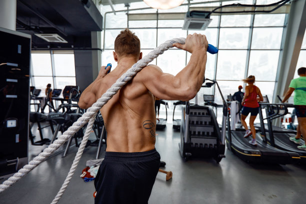 肌肉强大好斗的男子训练与绳子的功能训练健身馆。运动模糊图片下载