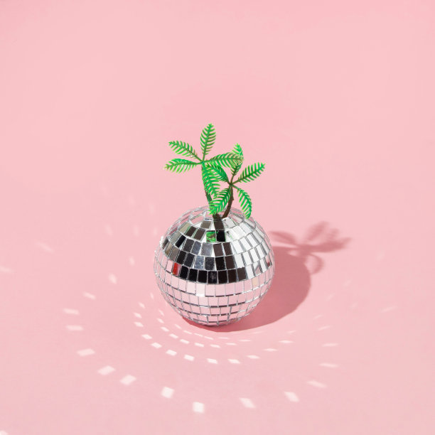 创造性的布局与迪斯科球装饰和棕榈树在粉彩粉红色的背景。八九十年代审美时尚夏季派对概念。时尚度假的主意。图片下载
