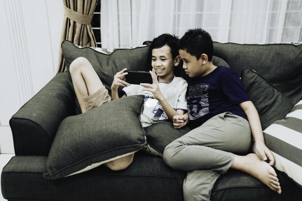 孩子们玩着现代移动设备——平板电脑和智能手机图片下载