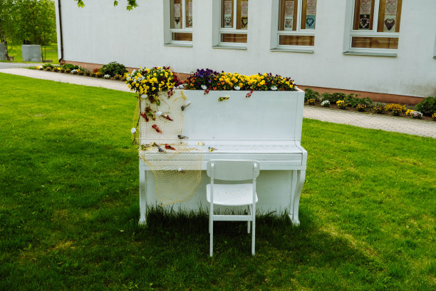 夏天花园里的白色钢琴和椅子，装饰浪漫。婚礼或浪漫晚餐的装饰。户外摆着一架装饰着鲜花的三角钢琴。花园装饰。乡村。庆祝活动图片下载