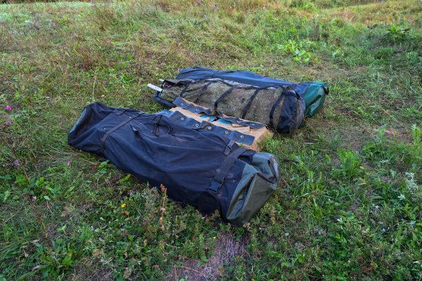 徒步旅行的包和皮划艇的背景是一个夏天的田野在日出。冒险旅游的生活方式。概念旅游热。活跃的周末假期野外自然户外。图片下载