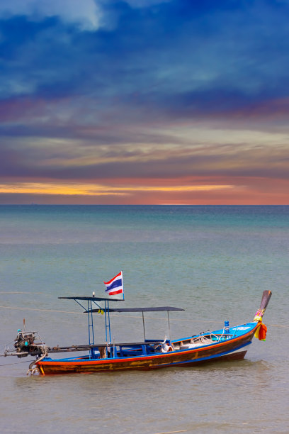在泰国普吉岛的巴东海滩上的彩色日落长尾船图片下载