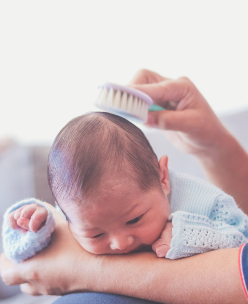 新生儿的头发和一把梳子图片下载