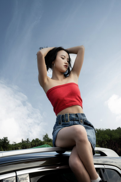 穿着红色衣服的时髦女人坐在屋顶上图片下载