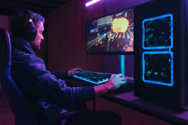 职业玩家在黑暗的霓虹灯房间里玩多人电脑游戏图片下载