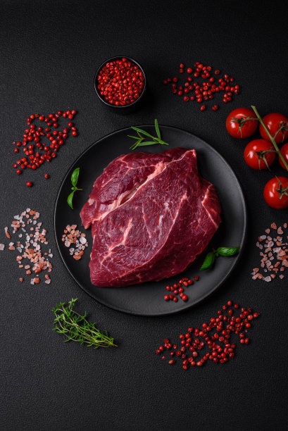 新鲜的生牛排，加盐，香料和香草图片下载