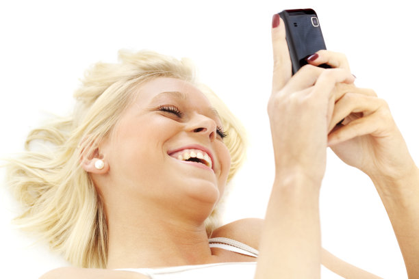 用智能手机微笑的金发少年图片下载