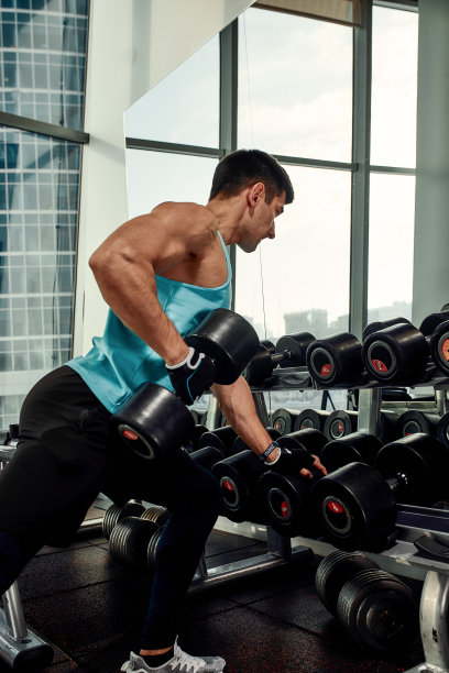 运动男子用哑铃摇二头肌。健康的生活方式的概念图片下载