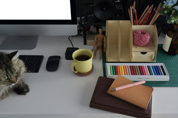 上图是家庭办公桌，配有电脑，咖啡杯，各种用品和可爱的猫咪。图片下载