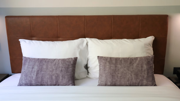 灰色的靠垫和白色的枕头作为现代卧室内饰与时髦的室内家居形象的结合图片下载