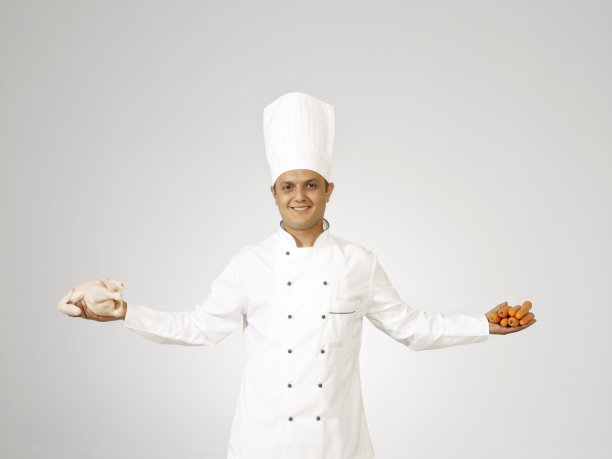 厨师拿着生鸡肉和胡萝卜图片下载