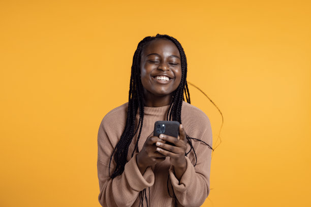 快乐的青少年拿着她的智能手机，从幸福中跳了出来。图片下载