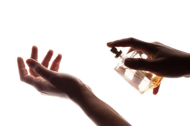 在白色背景上喷洒香水的女人的手的影子。简约风格香水模板。图片下载