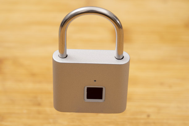 封闭式浅灰色挂锁，指纹开口。木色背景剪出。图片下载