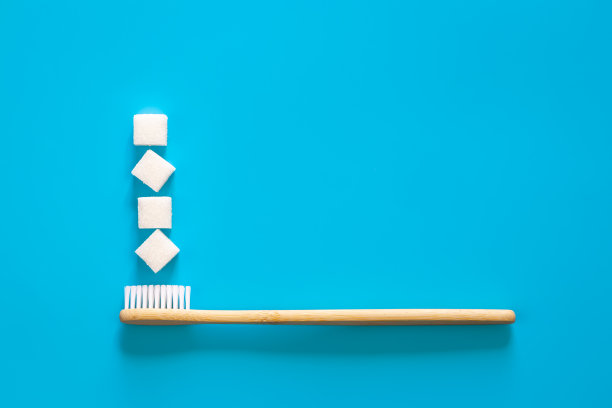 在蓝色背景上放上方糖牙刷，放平。图片下载