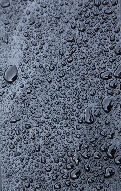 黑色橡胶表面上的雨滴特写图片下载