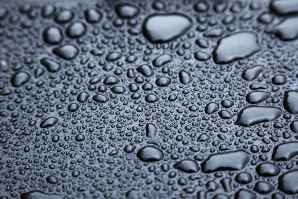 黑色橡胶表面上的雨滴特写图片下载