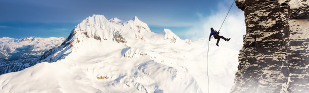 冒险的成年男子从岩石悬崖上滑下。极限冒险组合。图片下载