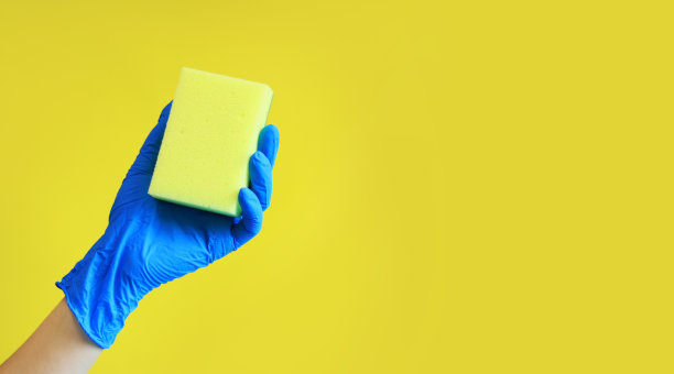 戴着手套的女人手里拿着洗碗用的海绵。清洁的广告图片下载