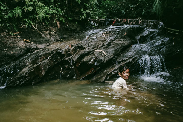 一个亚洲女孩在森林里的湖里游泳图片下载