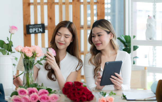 美丽的亚洲女花店制作花束。图片下载