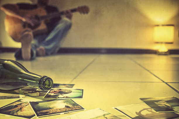 一个人独自坐在地板上弹吉他图片下载